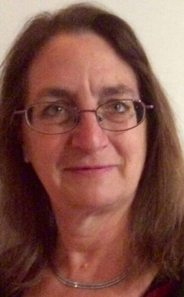 Image of American Music Therapist, Elizabeth K. Schwartz. She has shoulder-length brown hair and glasses and is wearing a black shirt.