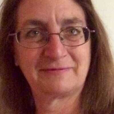Image of American Music Therapist, Elizabeth K. Schwartz. She has shoulder-length brown hair and glasses and is wearing a black shirt.