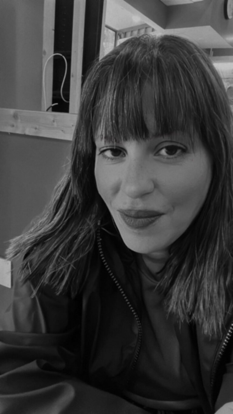 Music therapist, Hala Hamdan, who has dark, straight, shoulder-length hair, and is wearing a dark-colored jacket